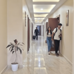 Well-lit hotel corridor with guests walking in Orai