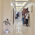 Well-lit hotel corridor with guests walking in Orai