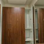 Wooden wardrobe with storage in deluxe room of hotel in Orai UP